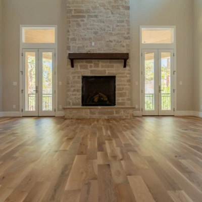Straight-plank white oak floor extending toward a centered stone fireplace